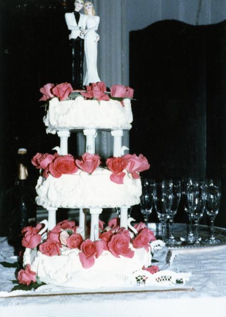The wedding cake with champagne glasses and a champagne bottle in the background